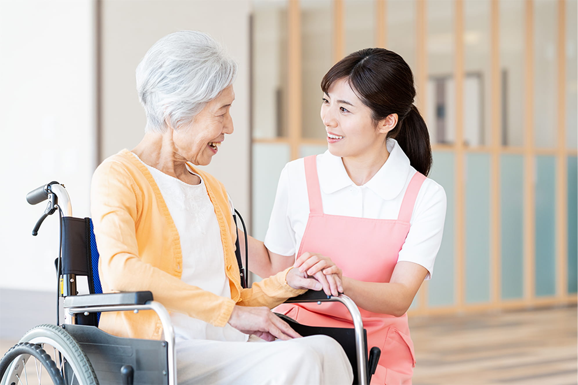 訪問看護ステーションで車いすの利用者を介助する看護師